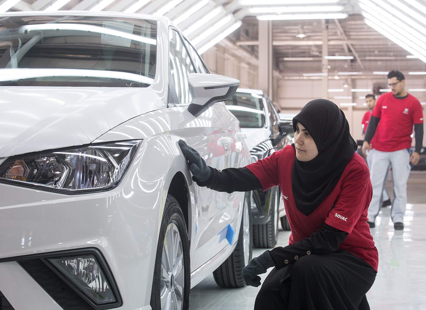 SEAT Nous sommes mondiaux Femme SEAT Usine inspectant une nouvelle voiture à la roue avant gauche - Ressources humaines SEAT