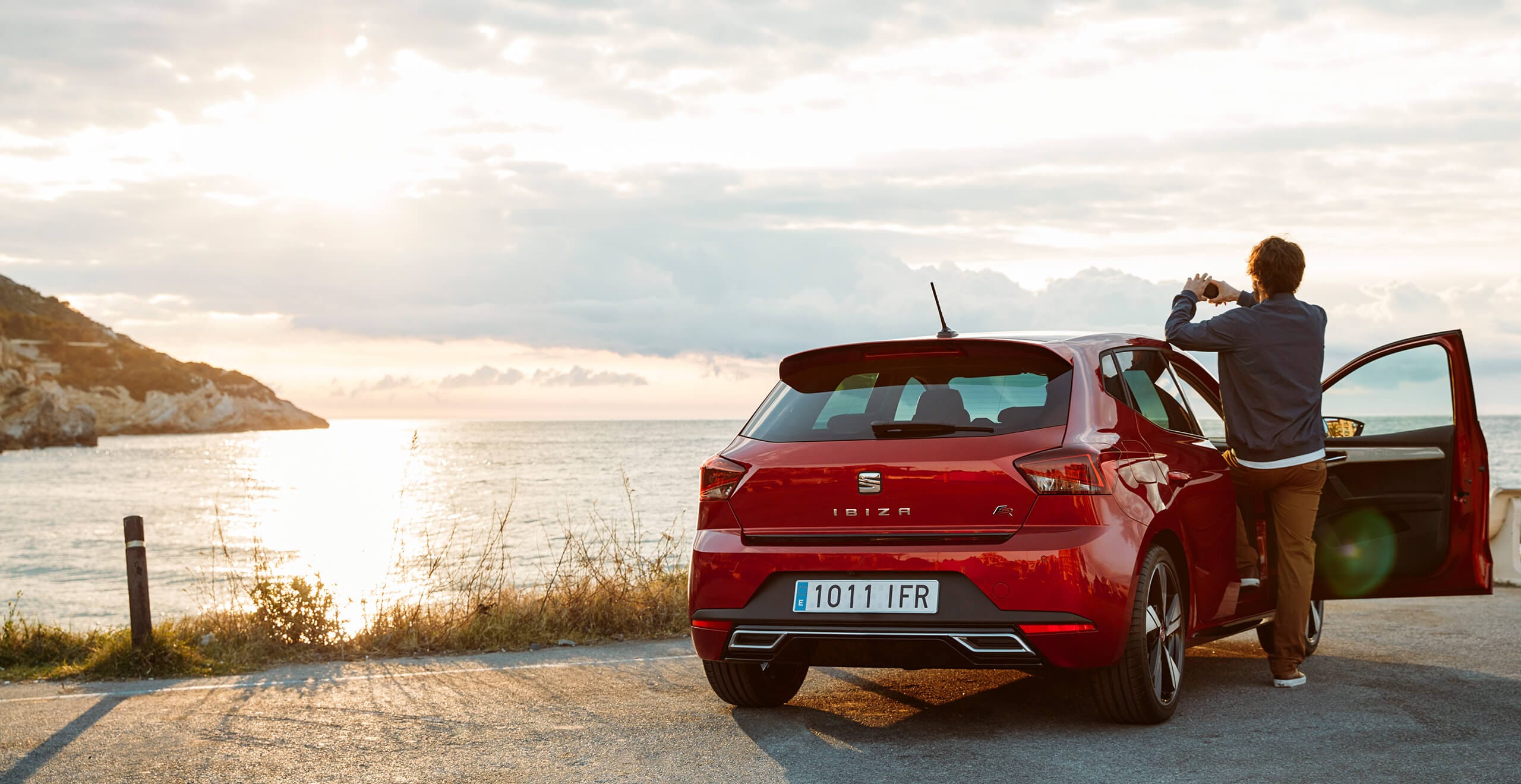 SEAT services et entretien des voitures neuves - SEAT Ibiza homme prenant une photo de la mer par la porte ouverte