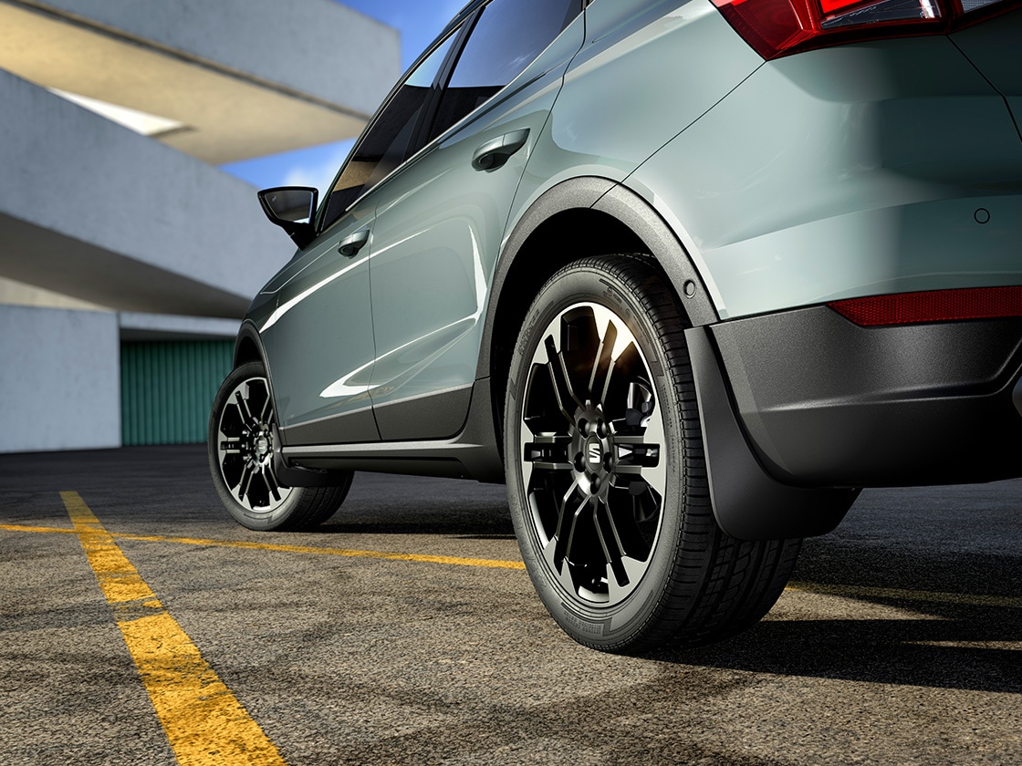 SEAT Arona noire avec des pare-boue avant et arrière assorties, protégeant le véhicule tout en renforçant son style. SEAT Arona noire avec des pare-boue avant et arrière assorties, protégeant le véhicule tout en renforçant son style.