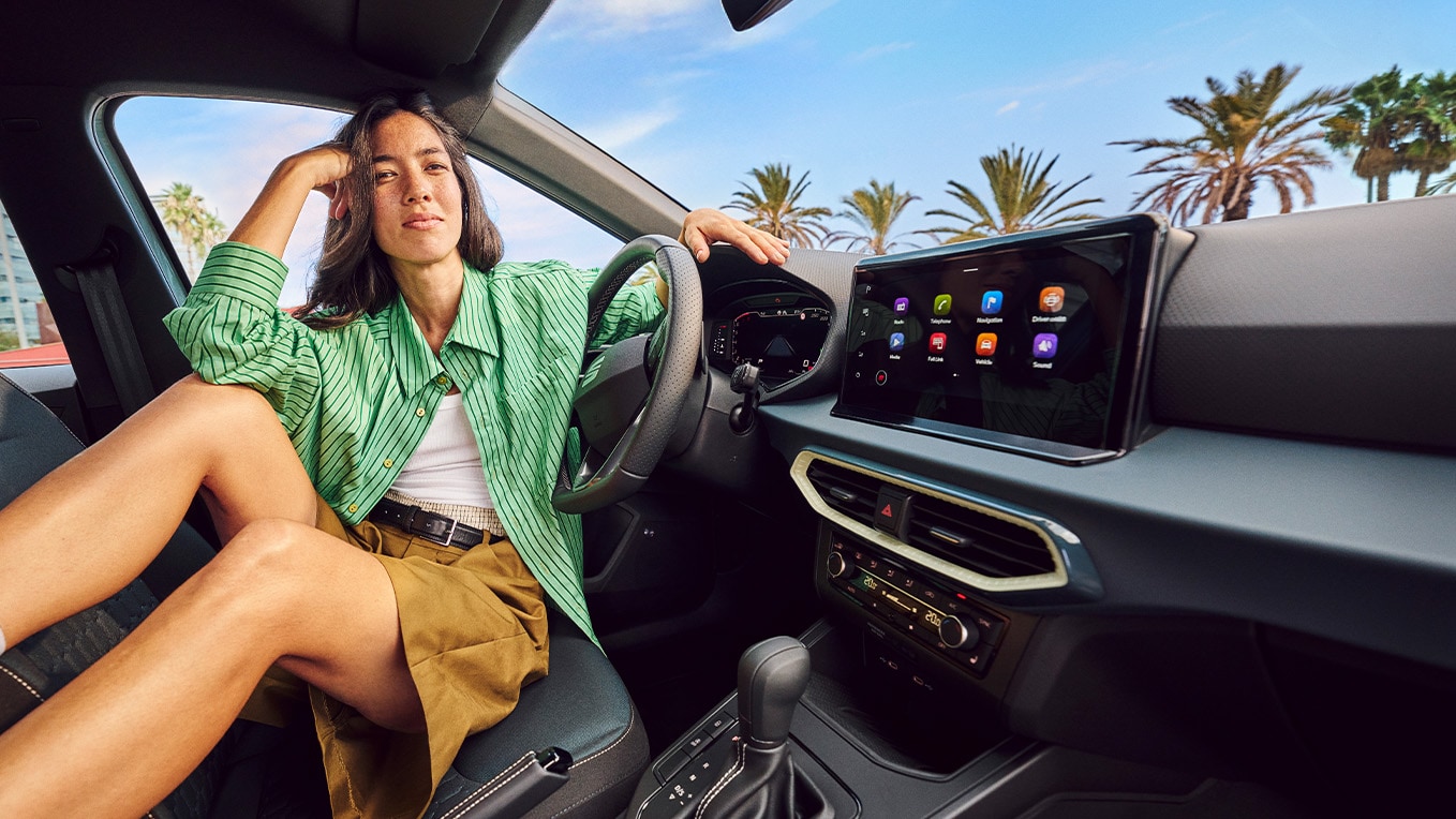 Vue intérieure de la SEAT Arona montrant le système de navigation avancé, avec un écran de 9,2 pouces et un cadre urbain élégant à l'extérieur.