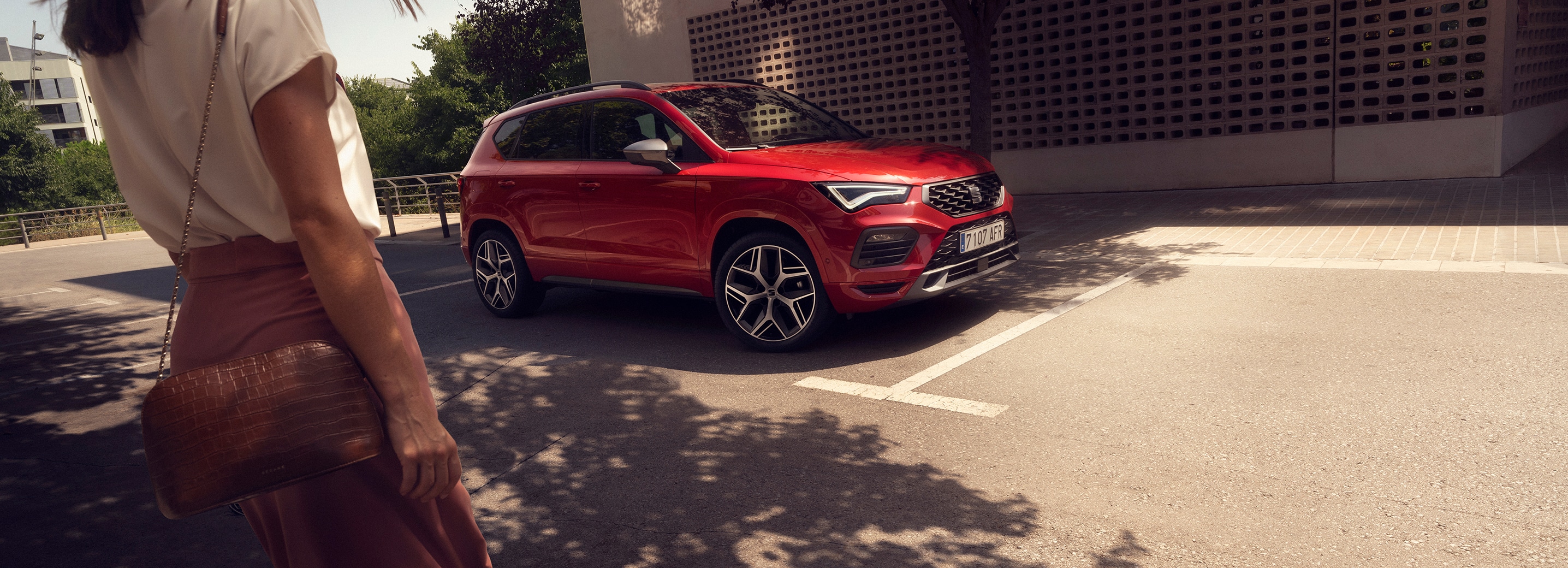 une personne s’approchant d’une seat ateca rouge garée dans la rue