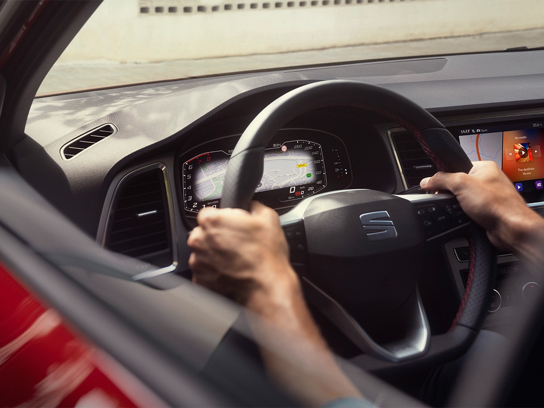 Vue intérieure de la seat ateca montrant le volant et évoquant la tranquillité d’esprit au volant grâce au service seat service mobility qui offre une assistance routière.