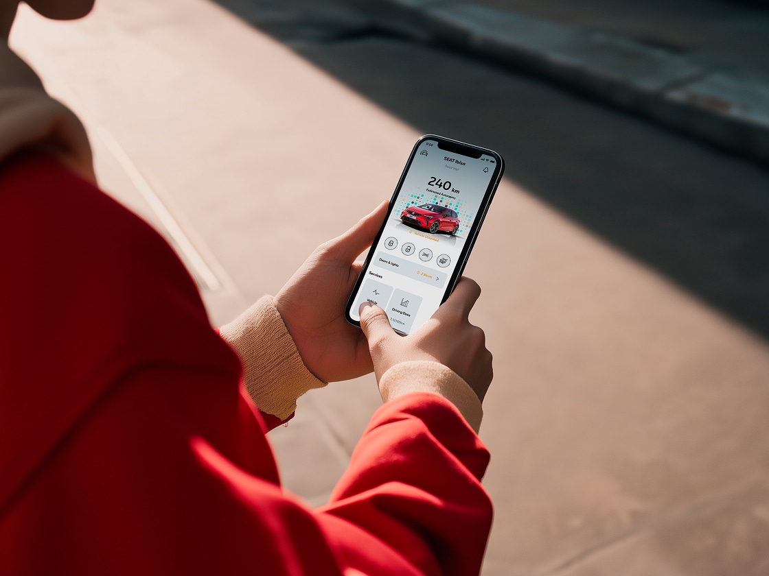 Personne tenant son smartphone et utilisant les fonctions à distance de SEAT Personne tenant son smartphone et utilisant les fonctions à distance de SEAT