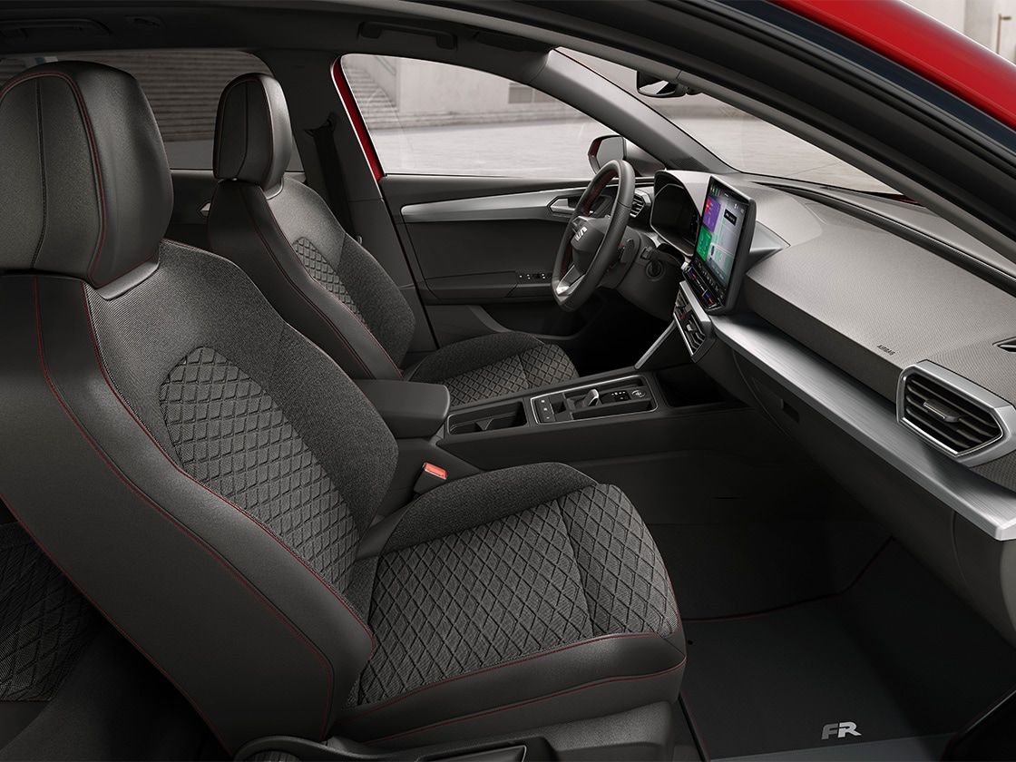 Vue intérieure de la SEAt Leon mettant en avant les sièges confort en tissu pour le modèle FR, alliant soutien ergonomique et design élégant pour un voyage confortable.