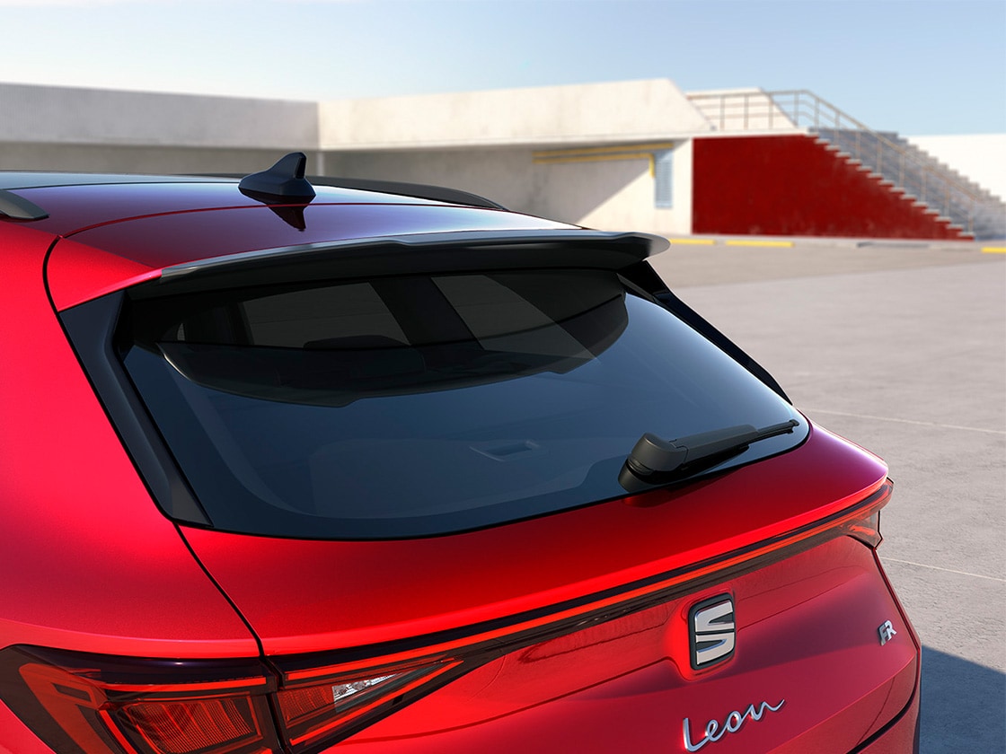 Une SEAT Leon rouge avec un aileron de toit sportif, améliorant le flux aérodynamique et les performances pour les finitions d’entrée de gamme ou avancées.