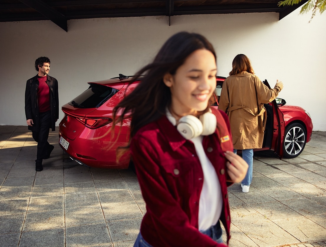 homme s’éloignant de la SEAT Leon Sportstourer 2024 couleur rouge désir avec jantes en alliage