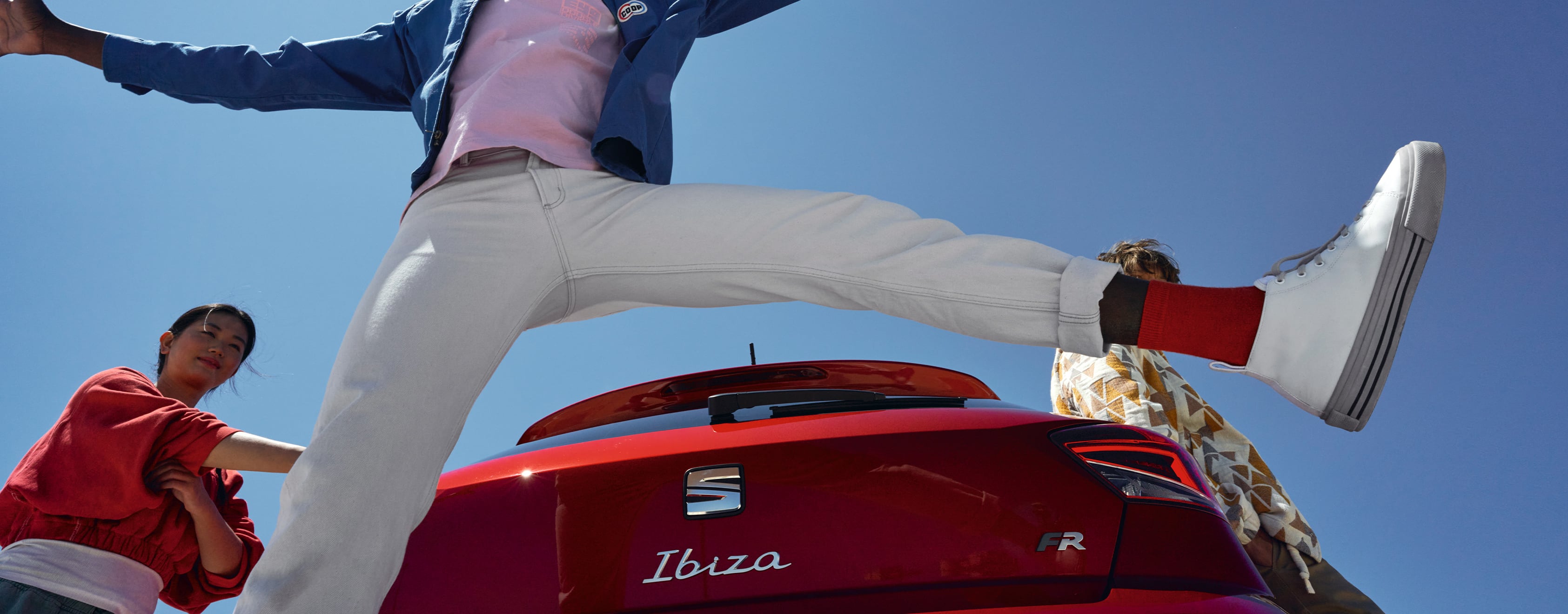 Homme, sautant devant la SEAT Ibiza peinture Rouge Désir finition FR