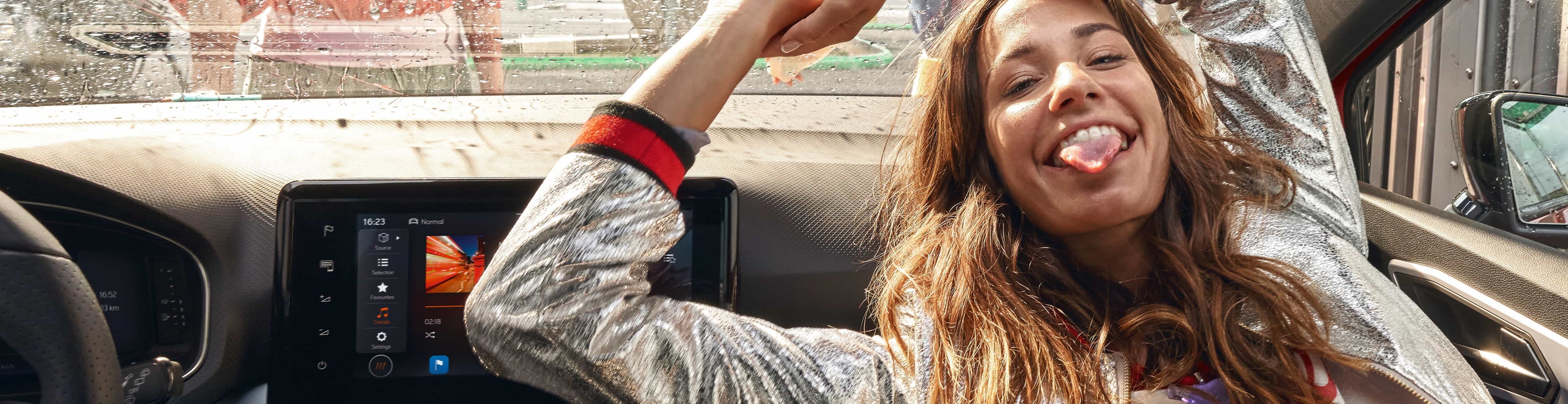 Femme à l'intérieur d'une SEAT Ibiza tirant la langue