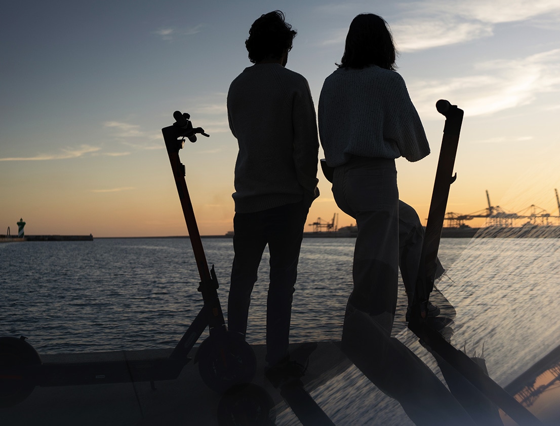 Friends looking at the sunset with their SEAT MÓ 65 electric scooter 