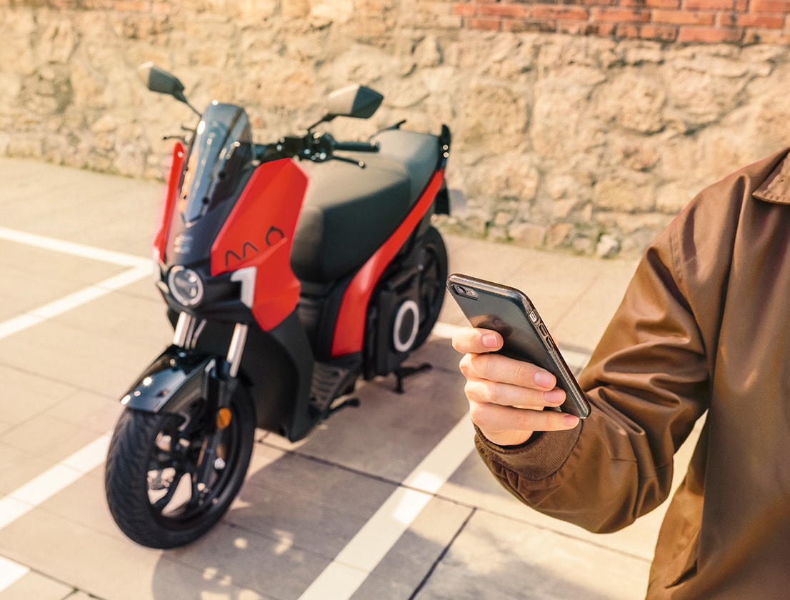 person connecting their SEAT MÓ 125 electric scooter with smartphone app