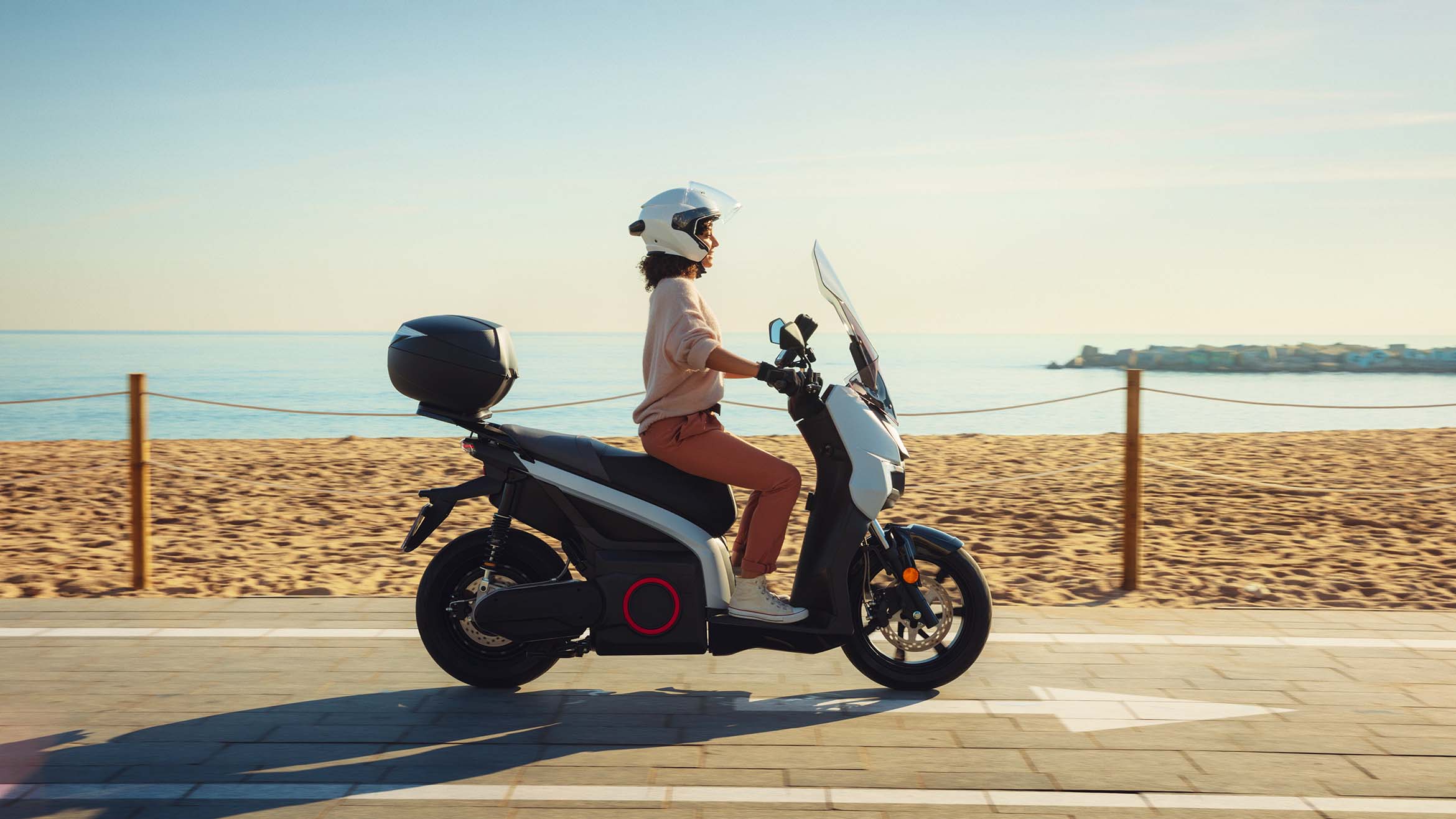 Person riding white SEAT MÓ 125 electric scooter