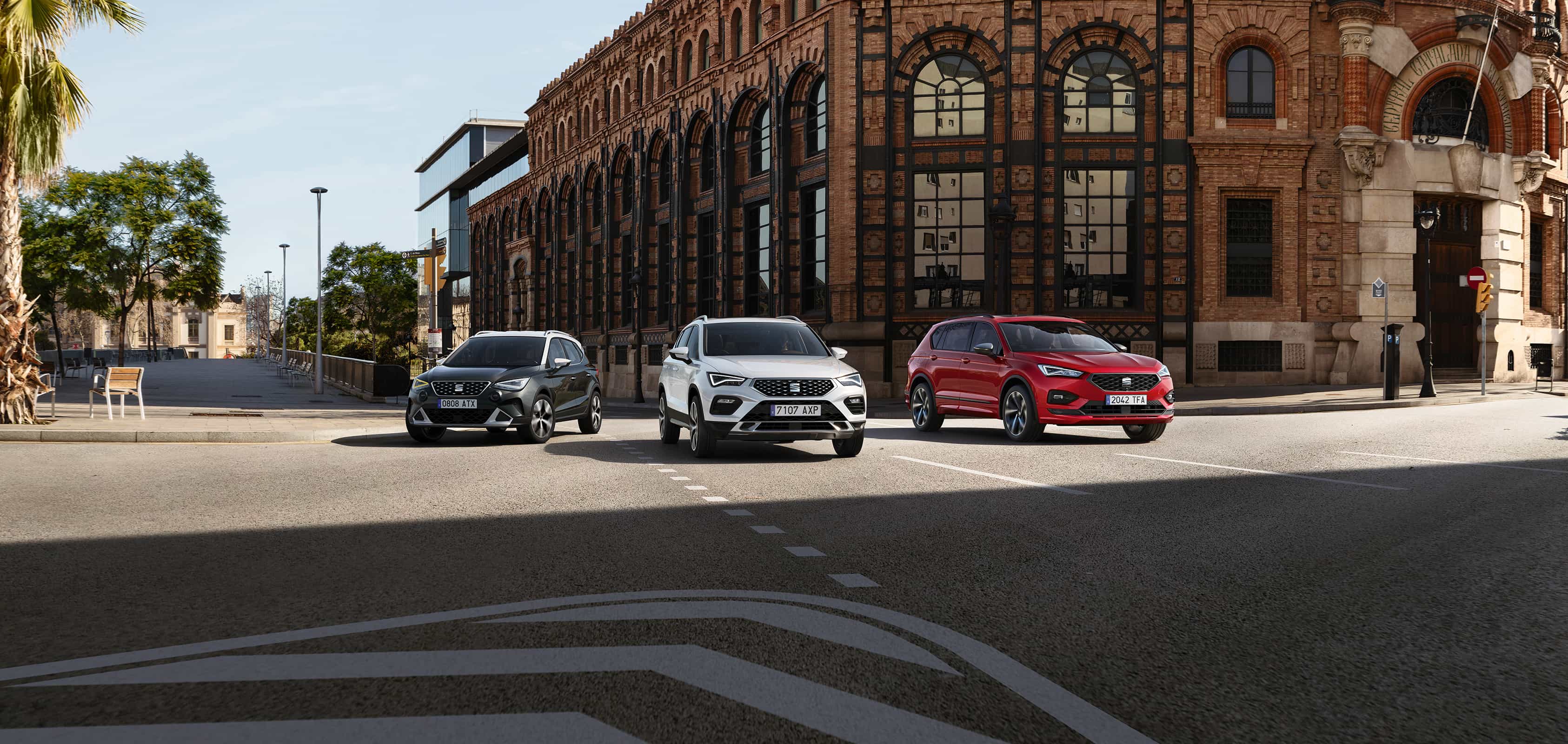SEAT Arona couleur gris caÏman à côté de la SEAT Ateca couleur Blanc Bila et de la SEAT Tarraco couleur Rouge Velvet