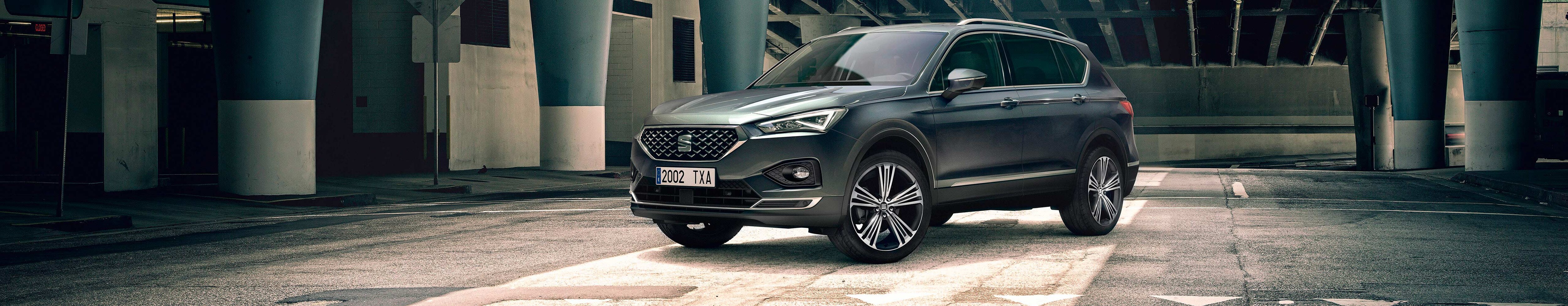 Nouvelle SEAT Tarraco SUV 7 places garée à l'extérieur d'un bâtiment 