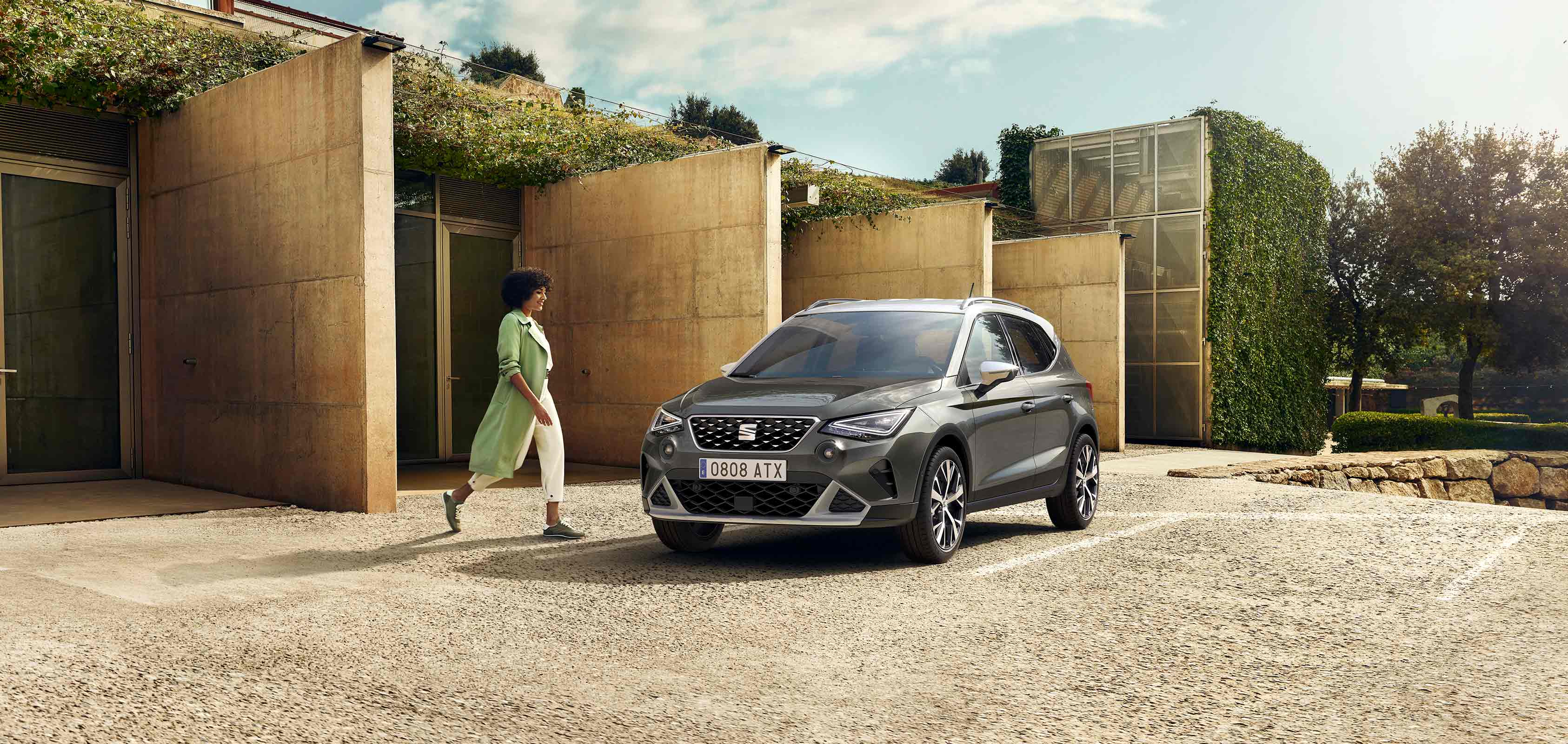 Femme marchant vers la SEAT Arona couleur gris falaise