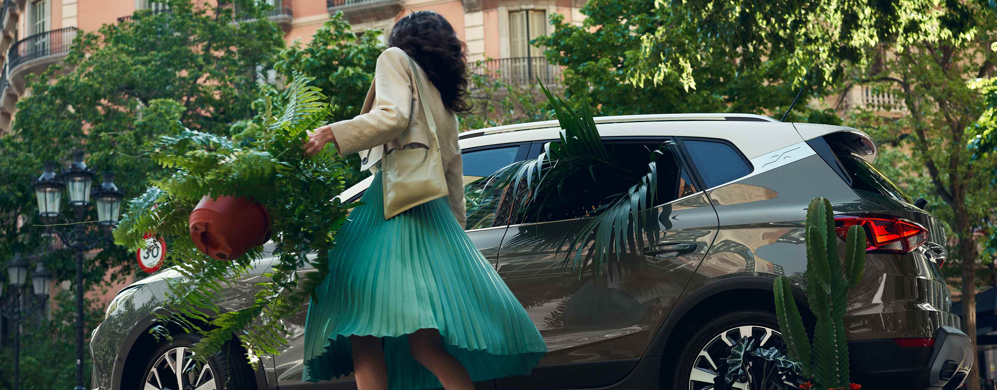 Femme avec une plante ouvrant la SEAT Arona couleur gris falaise