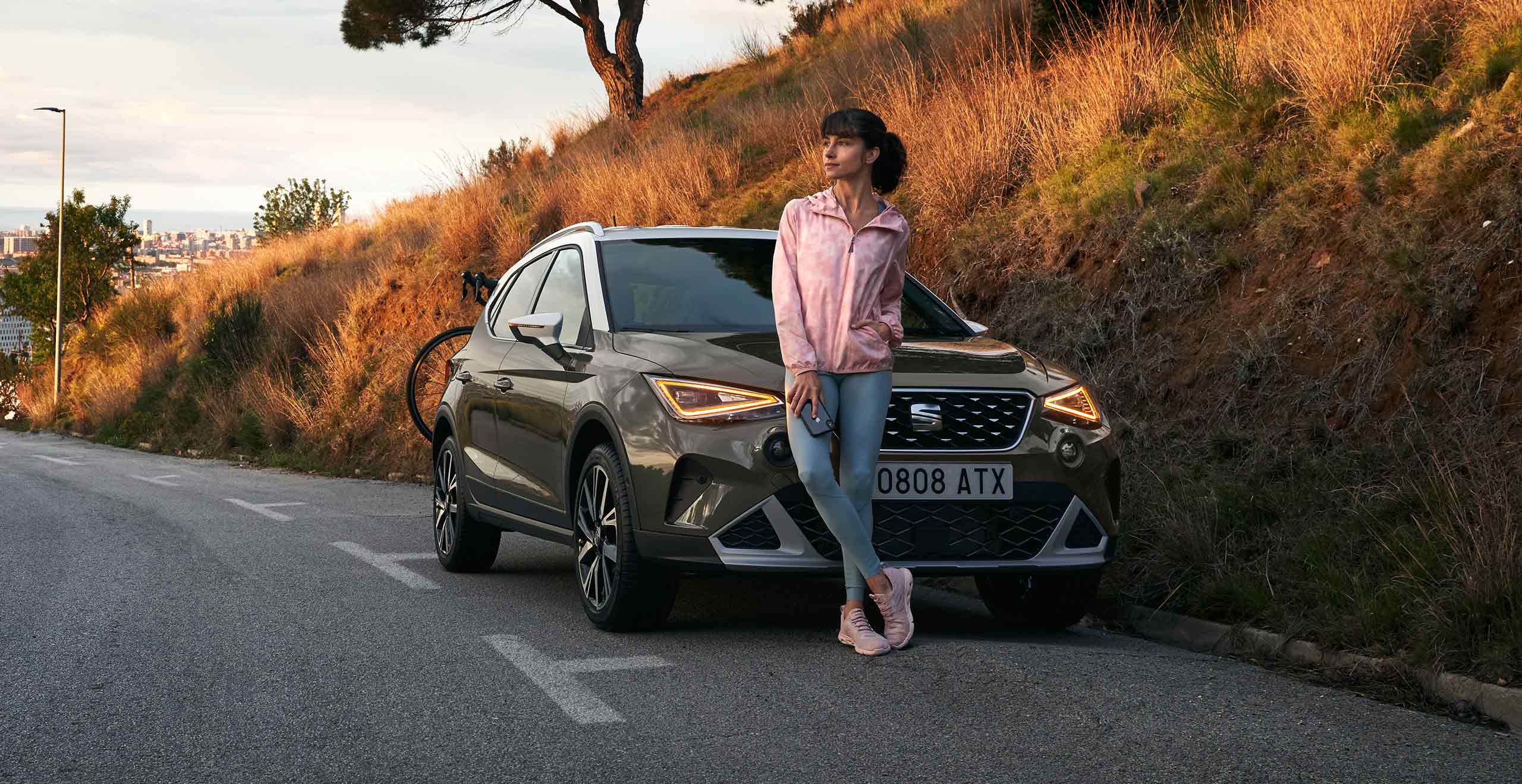 Femme avec une plante ouvrant la SEAT Arona couleur gris falaise