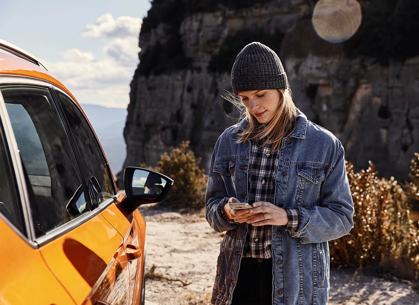 Services et entretien des voitures neuves SEAT - Femme au téléphone à côté d'un SUV SEAT Ateca en stationnement