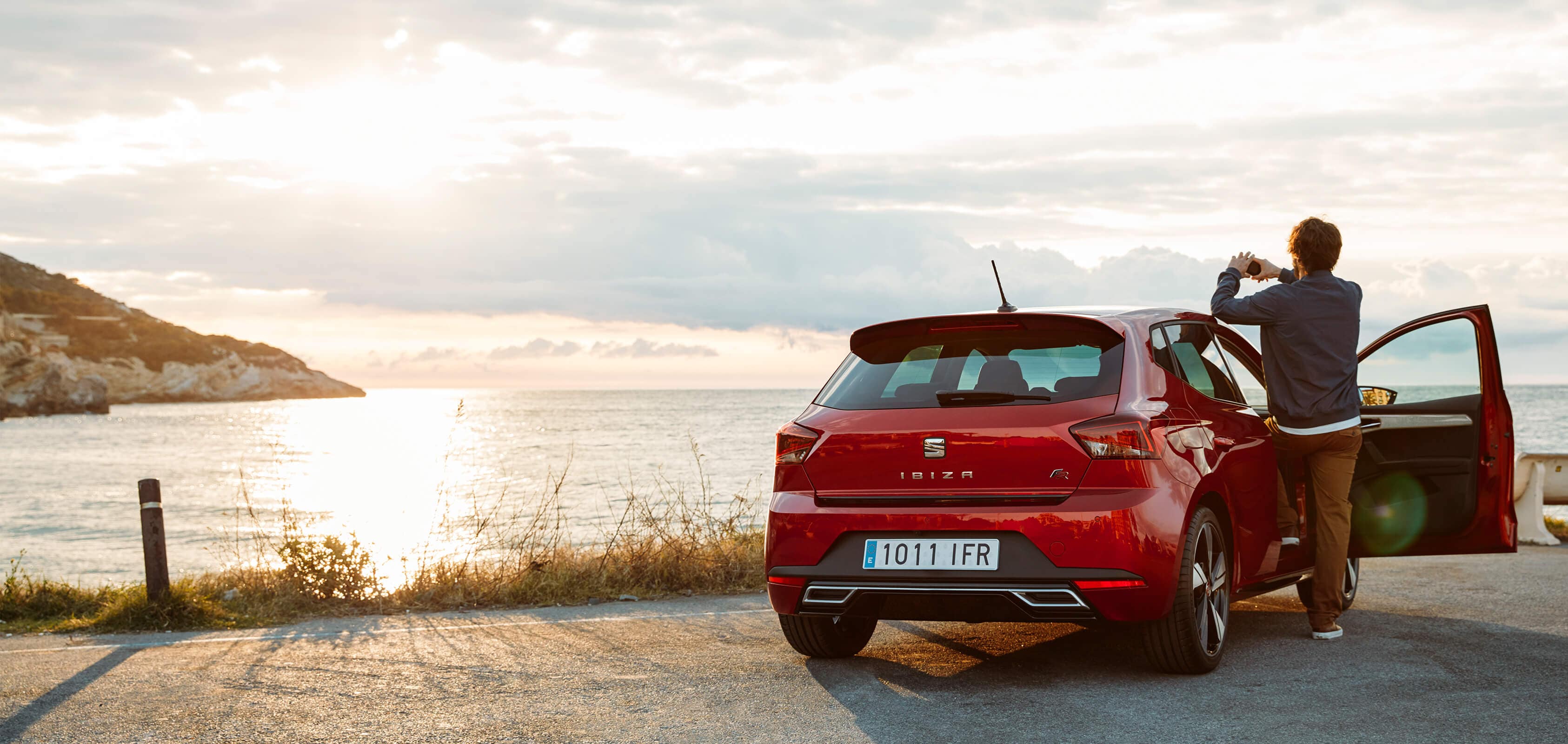 SEAT services et entretien des voitures neuves - SEAT Ibiza homme prenant une photo de la mer par la porte ouverte