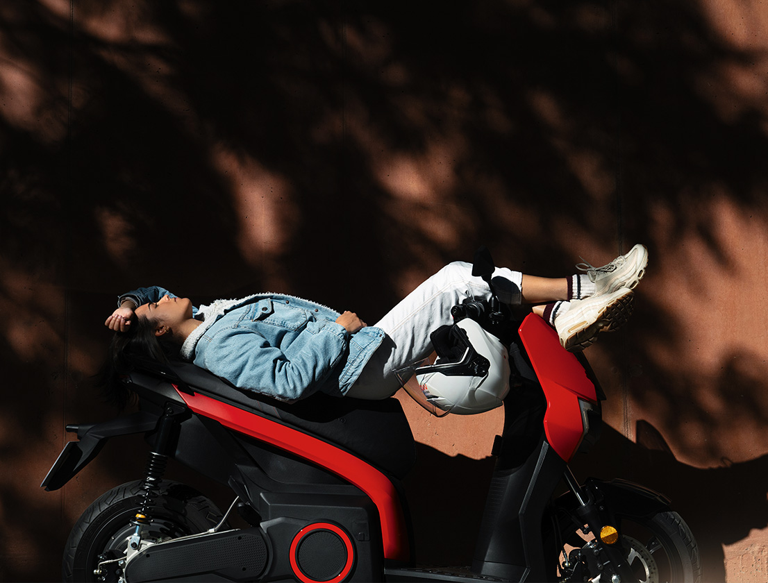 Femme allongée sur son scooter électrique SEAT MÓ 125